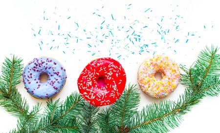 Colored donuts with colorful sprinkles on white background. Christmas and New Year celebration concept. Copy space, close-upの写真素材