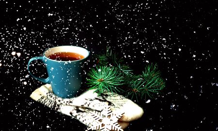 Cup of  tea on knitted mittens. Christmas background. Hygge style. Close-up, copy space