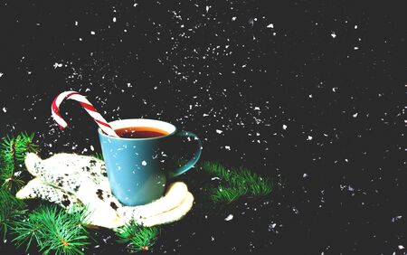 Cup of tea on knitted mittens. Christmas background. Blurred effect. Hygge style. Close-upの写真素材