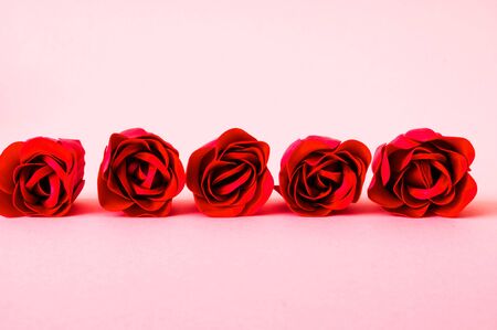 Festive concept from red rosebuds on pink background. Valentines Day. Template mock up of greeting card or text design. Close-up, copy spaceの写真素材