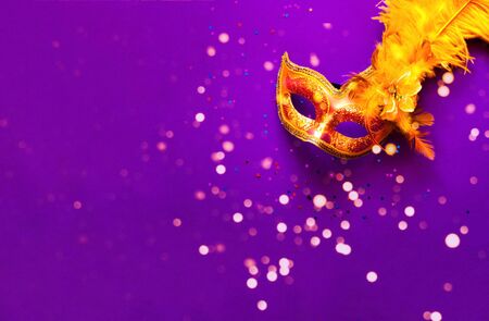 Carnival mask on purple background with sparkles. Festive backdrop for projects.Close-up. Copy spaceの写真素材