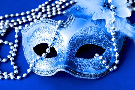 Carnival mask on blue background with silver beads. Mardi Gras concept. Copy space, close-upの写真素材
