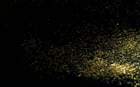 Black background with golden sparkles. Blurred effect. Concept for festive background or for project.Close-up,copy spaceの写真素材