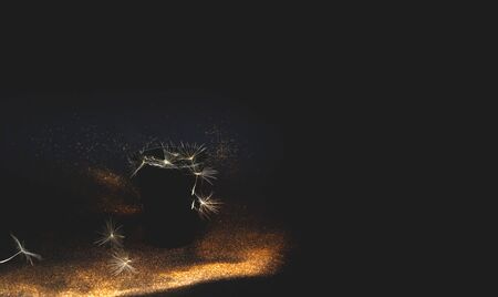 Paper disposable cup and dandelion inflorescence on black background with golden sparkles.Blurred...