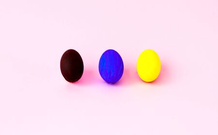 Colorful easter eggs on a pink background. Festive concept, minimalism. Close-up, copy spaceの写真素材