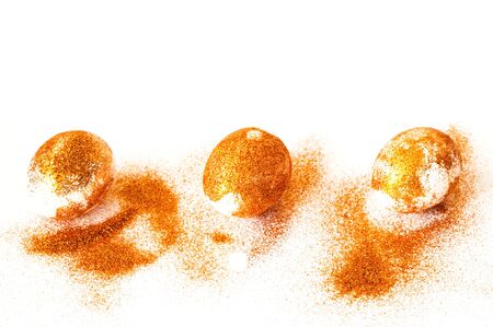 Easter eggs decorated with golden spangles on white background. Festive concept, minimalism....