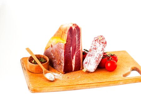 Authentic Italian Prosciutto Dry-Cured on wooden board. Air-Dried Ham and organic tomatoes. Close-up, isolated, copy spaceの写真素材