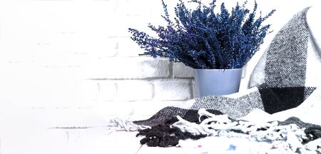 Cozy checkered plaid and heather flowers on wooden background. Hyugge style. The concept of home comfort. Close-up, copy space.の写真素材