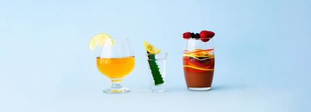 Quarantini or homemade alcohol drink with wild berries on blue background. The concept of new popular drinks. Close-up, copy spaceの写真素材