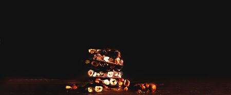 Chocolate with nuts on dark background. World Chocolate Day or happiness is in small things. Close-up, copy spaceの写真素材