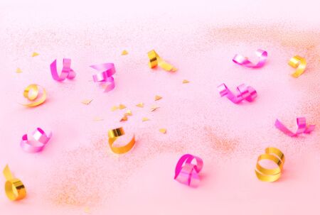 Confetti on pink background with golden sparkles. Concept for festive background or for project.の写真素材