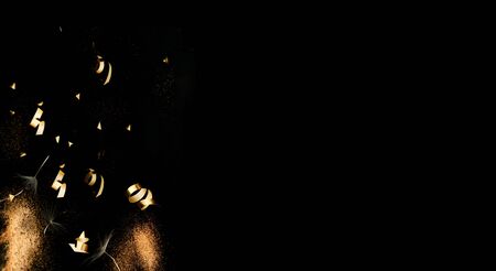 Confetti on dark background with golden sparkles and white dandelion inflorescences. Concept for festive background or for project.の写真素材