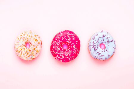 Colored donuts with colorful sprinkles on pink background. National Pink Day or Doughnut day concept.の写真素材