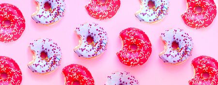 Colored donuts with colorful sprinkles on pink background. National Pink Day or Doughnut day concept.の写真素材