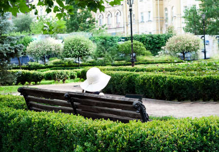 Girl in white hat with laptop in city park. Social Distancing concept.の写真素材