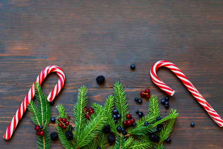Fir branches and berries on wooden background. Homemade Christmas Decor or decoration on budget....