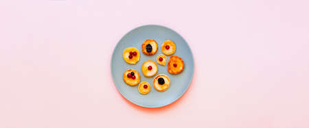 American pancakes with strawberries in blue plate on pink background. National pancake Day or Tiny...