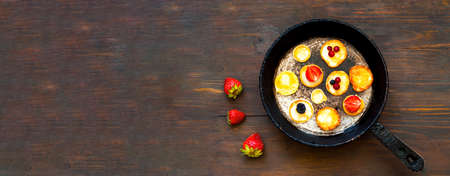American pancakes with strawberries in authentic frying pan on wooden background. National pancake Day or Tiny pancake cereal. Creative copy spaceの写真素材
