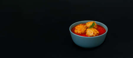 Meat balls in tomato sauce in blue bowl on dark background.Close-up