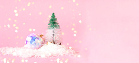 Decorative Christmas tree and neon ball on a pink background with snow. Festive concept with blurred effect. Creative copy space. Close-upの写真素材
