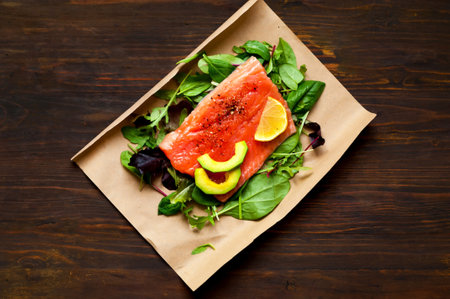 Salmon fillets with spinach and avocado in sustainable packaging on wooden background. Concept health-conscious. Close-up, copy space. Top view.の写真素材