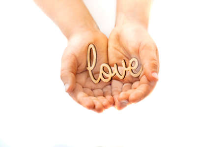 Festive layout. Little hands of child hold in the palm of stamp the word love. Copy space