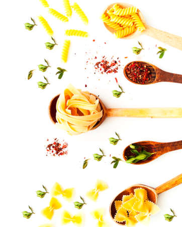 Wooden spoons with pasta and spices on white isolated background. The concept of Italian cuisine. Close-upの写真素材