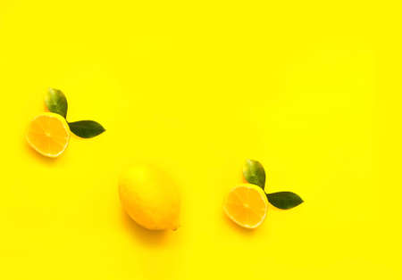 Whole and half lemon on yellow background. Color of the year 2021. Creative copy space, close-upの写真素材