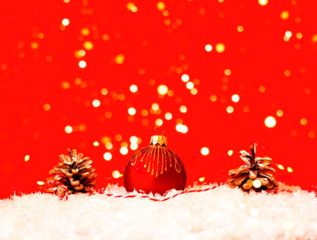 Red Christmas bauble on snow texture. Christmas greeting card with place for your text.