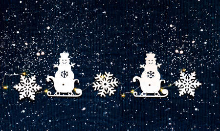 Winter pattern on knitted texture made of snowflakes, snowman and sledges. Christmas decor or hygge style. Creative copy space.の写真素材