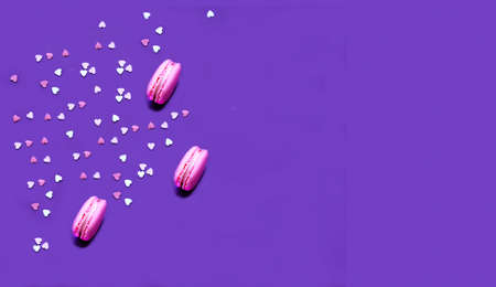 Pink macarons on perfect purple background. Creative copy space for positive mood