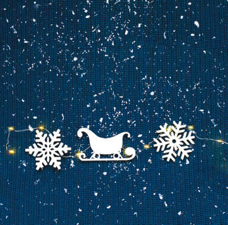 Winter pattern on knitted texture made of snowflakes and sledges. Christmas decor or hygge style. Creative copy space for seasonal projects, close-upの写真素材