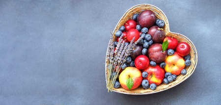 Red apples in straw basket made in the shape of heart on white background. Religious holidays concept - Jewish New Year or Apple spas. Copy spaceの写真素材