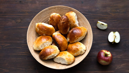 Homemade pies with apples in bamboo basket on wooden background. Cooking concept. Close-upの写真素材