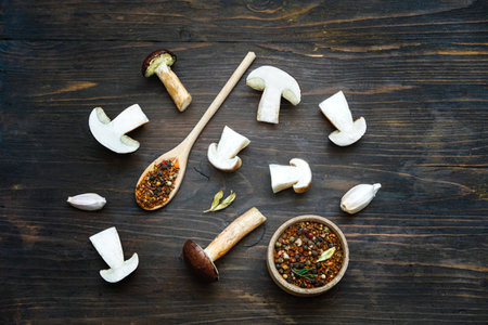 Different fresh wild mushrooms and spices on wooden background. Autumn Cep Mushrooms. Concept organic food mushroom. Close-upの写真素材