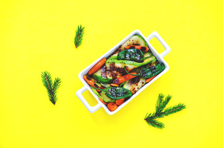 Baked or grilled vegetables on yellow background. Cooking delicious food at home.の写真素材
