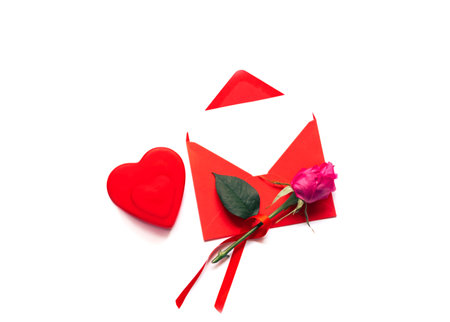 Red envelope with decorative hearts and rose flowers on white background. Festive background concept...