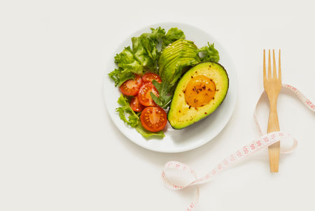 Baked egg with avocado and lettuce leaves on white plate. Healthy and balanced products. Fodmap diet concept.の写真素材