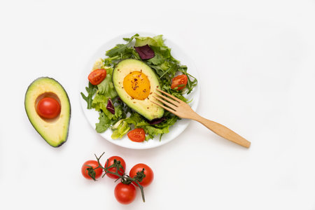 Baked egg with avocado and lettuce leaves on white plate. Healthy and balanced products. Fodmap diet...