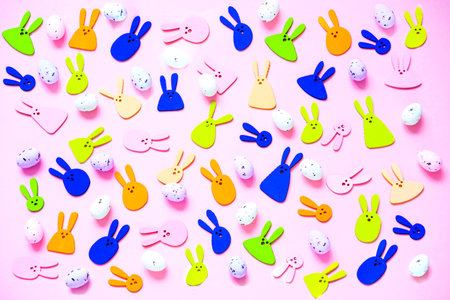 Pattern of decorative rabbits and colored eggs on pink background. Happy Easter concept. Bold hues for seasonal projects.の写真素材