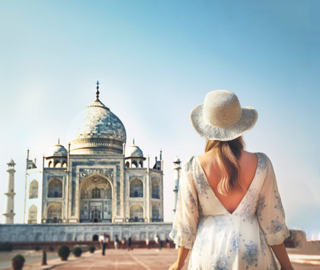 Young girl in beautiful dress and hat looks at the Taj Mahal mosque. An exciting journey through India. Close-up. Generative AI contentの素材