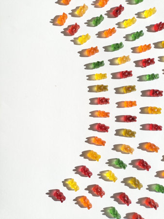 Gummy bears on a white background. Different colors: red, orange, yellow and green. There is negative space. Placed in a circle.の写真素材