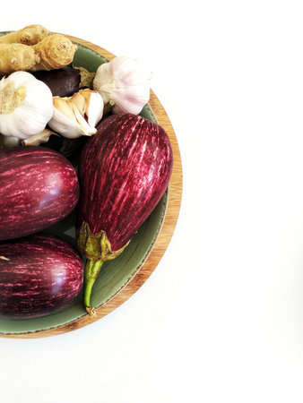 Raw vegetables on a plate. There is negative space and a white backgroundの写真素材