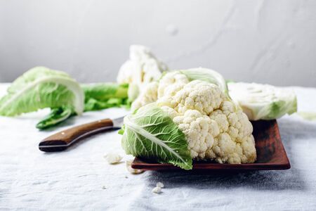 Fresh uncooked cauliflower on a table with a white tablecloth.の写真素材
