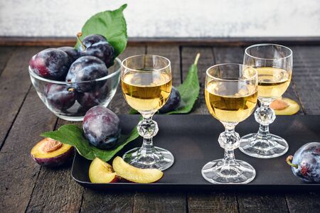 Plum vodka in glasses and fresh plums.の写真素材