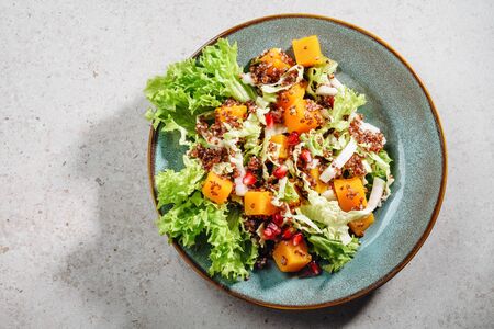 Salad with kale, lettuce, pumpkin, red quinoa and pomegranate seeds.の写真素材
