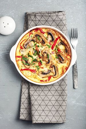 Frittata with mushrooms and sweet pepper on a gray wooden table.の写真素材