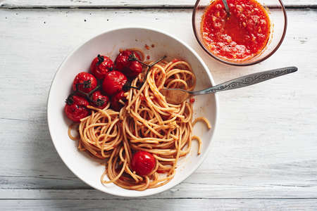 Spaghetti pasta with tomato sauce and roasted cherry tomatoes.