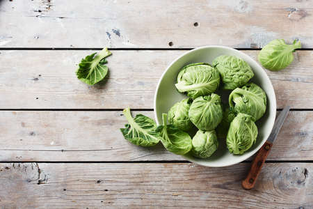 Fresh green Brussels sprouts in a bowl, top view.の写真素材
