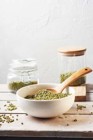 Raw mung beans in a bowl on a wooden table.の写真素材